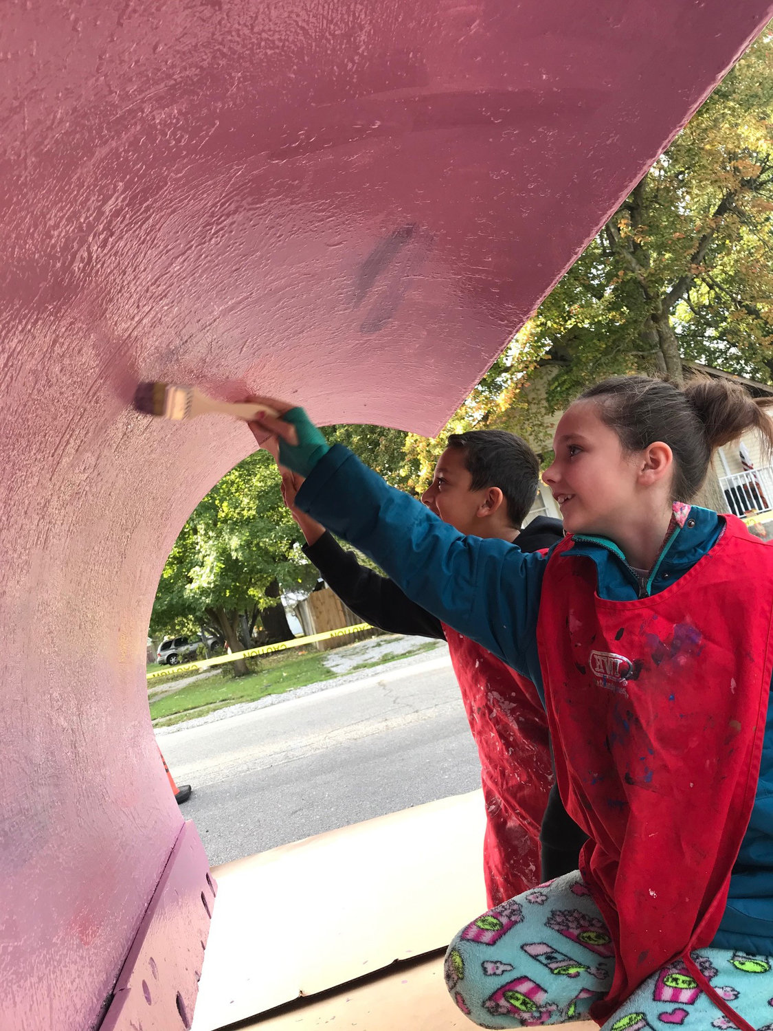 Students paint the underside of a plow, which will appear in the Crawfordsville Christmas parade.